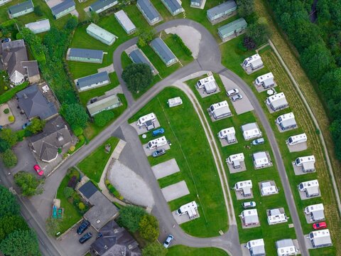 Aerial view of a holiday caravan park in Pateley Bridge North Yorkshire showing touring caravans static holiday homes internal roads landscaped pitches and surrounding countryside beside woodland