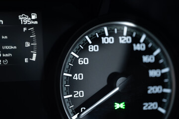 Fototapeta premium Car dashboard shows speedometer and fuel level in night setting