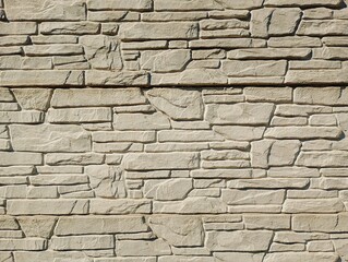 Fototapeta premium A premium textured full-frame photograph of a modern cladding wall built from rustic stacked natural stone tiles. This beautiful architectural surface showcases a rugged split-face texture in a unifor