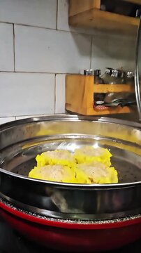 Opening a traditional bamboo steamer revealing a freshly cooked giant dim sum with thick hot steam rising, authentic Asian culinary concept.