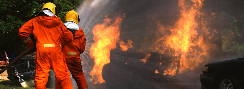 Banner Fireman wear hard hat, safety suit with copy space. Banner Firefighter Rescue training fire fighting extinguisher. Fire burn car accident disaster conflagration. Firefighter fighting flame