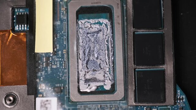 An orbiting perspective shows a GPU chip with aged and dried-out thermal grease. The visible electronic components on the circuit board indicate the need for maintenance.