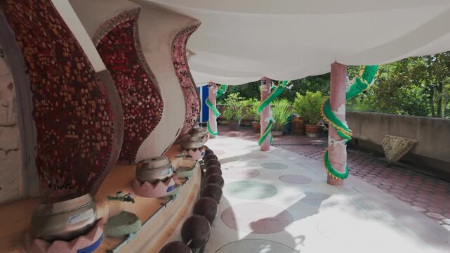The unique architecture of Wat Sam Phran temple in Nakhon Pathom, Thailand, features ornate dragon decorations and mosaic-covered walls,