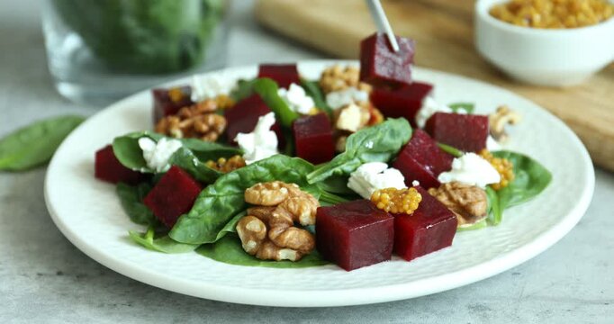 Eating tasty salad with boiled beets at grey table, closeup