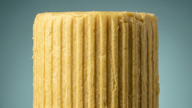 Macro Close-up of Textured Yellow Beeswax Block with Vertical Ridges