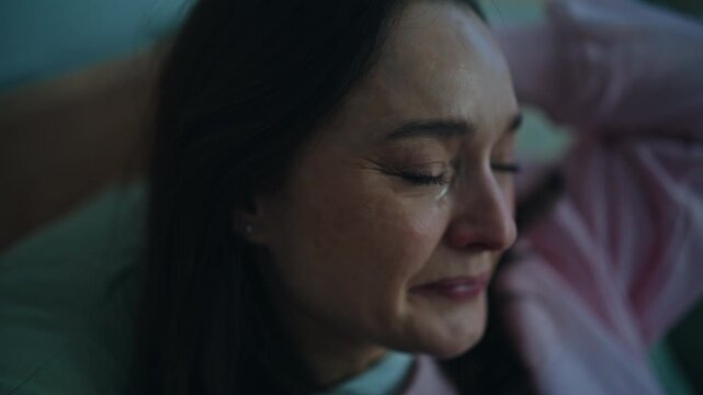 Heartbroken lady crying bed at sleepless evening home closeup. Brunette sadness