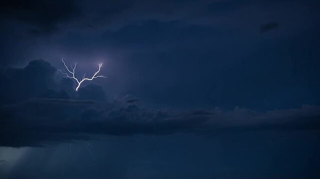 Powerful lightning bolts strike through dark storm clouds at night