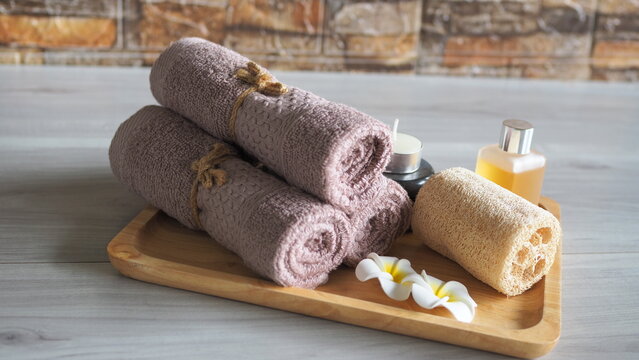 Minimalist flat lay coffee body scrub spa set with organic bath salt in a wooden bowl, a closed amber dropper bottle, cinnamon sticks, and neatly scattered roasted coffee beans. Top view on a warm rus