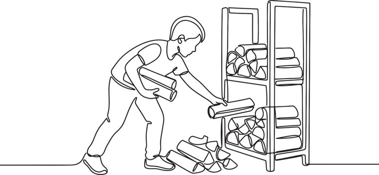 person stacking carpet rolls in a storage room