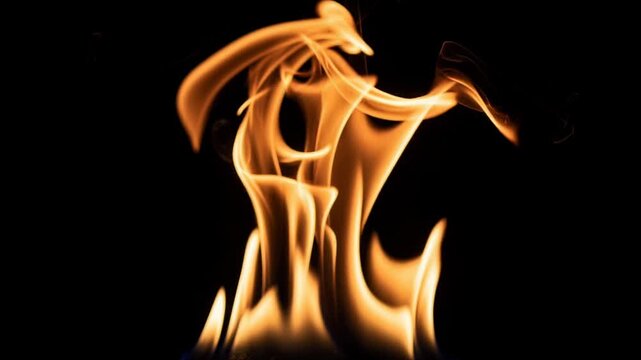 Mesmerizing slow motion video of vibrant flames dancing gracefully with dynamic fire motion and warm colors