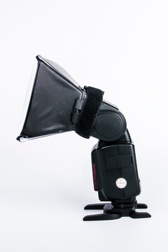 Professional speedlight flash with mini softbox modifier isolated on white background