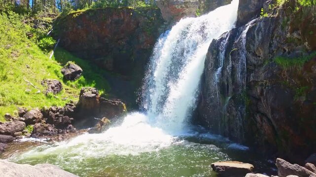 A silky cascade flows over Moose Falls into a rocky pool in Yellowstone National Park 