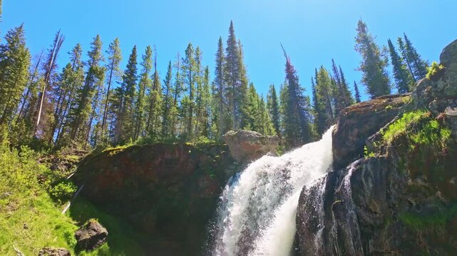 A silky cascade flows over Moose Falls into a rocky pool in Yellowstone National Park 