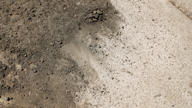 Damaged asphalt road surface texture with cracked concrete patch