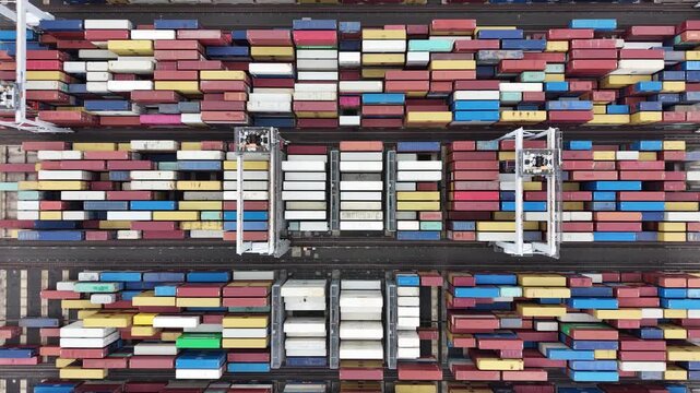 Aerial view of gantry cranes moving shipping containers at port terminal