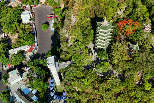 An aerial view captures the green layered temple at Marble Mountains, Da Nang, connected by an elevator and walkway