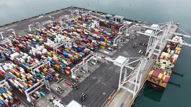 Aerial view of container ship unloading at a commercial port terminal