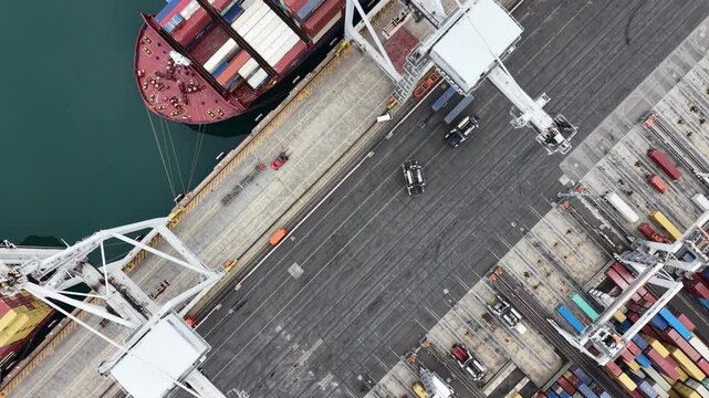 Aerial view of container ship unloading at port terminal
