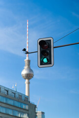 Obraz premium Ampel in der Innenstadt von Berlin. Im Hintergrund ist unscharf der Fernsehturm zu erkennen