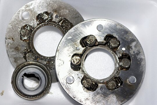 Disassembled e-bike motor sprag clutch with old worn grease on metal gears and metallic bearings, essential internal mechanical parts for electric bicycle hub motor repair and maintenance
