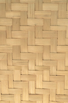 Close-up of woven bamboo pattern creating a natural geometric texture background with handcrafted organic material.
