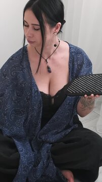 Vertical video. Meditation practice. Yoga board. Female sitting in lotus position spraying water for calming foot.