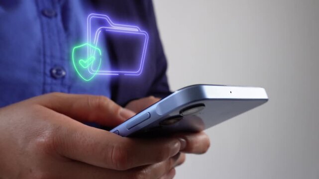 Privacy and security in files. Female corporate leader using her cell phone with a virtual folder icon and a shield containing a checkmark.