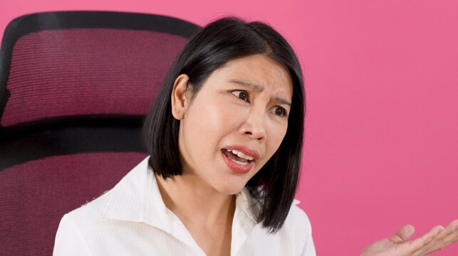 Frustrated Asian Woman Shrugging with Confusion in Office Chair