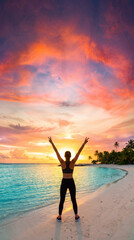 Fototapeta premium Breathtaking Dramatic Fit Female Silhouette Arms Raised in Victory Pose on Tropical Beach at Golden Hour With Turquoise Ocean