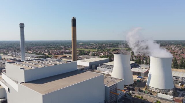 Aerial view of a multi fuel energy from waste power station. Steam rises from two large cooling towers.