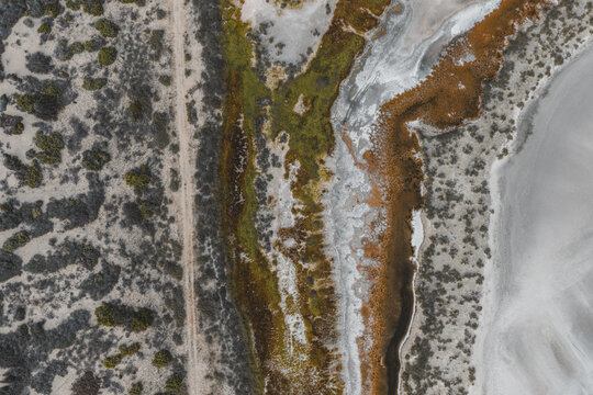 Aerial view of the coastal landscape near La Ventana, featuring salt flats, textured terrain, and natural vegetation patterns in La Ventana, Baja California Sur, Mexico.