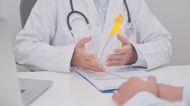 Doctor and patient having a medical consultation for Yellow Ribbon concept of yellow September, Suicide prevention day, Childhood, July Sarcoma, bone and bladder cancer, explaining treatment plan