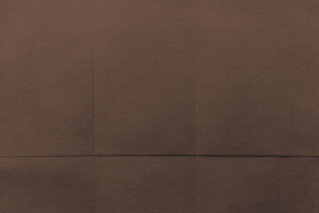 Fototapeta premium Brown textured fabric background with subtle folds and shadows.