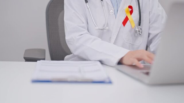 World hepatitis day awareness month, 28 July. doctor using laptop and report notes on notebook. Red and Yellow ribbon for Liver cancer, Jaundice, Cirrhosis, Failure, Enlarged, Hepatic Encephalopathy