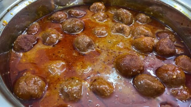 A beautifully presented dish of rich and creamy Malai Kofta, garnished with fresh cream and nuts, served at an elegant vegetarian marriage celebration in India.