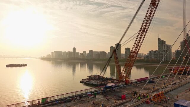 Aerial view of bridge sections being dismantled with a large crane over a river