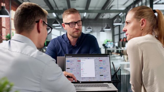 Finance Manager Reviews Corporate Expense Reports With Diverse Team