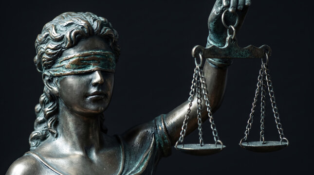 Bronze Lady Justice statue portrait, with blindfold holding balance scales, standing still, dark background, law and justice symbol