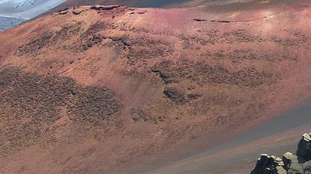 Slow motion pan left reveal of prominent red cinder cone within the Keoneheʻeheʻe (Sliding Sands) Valley of Haleakalā Crater, Haleakalā National Park, Maui, Hawaii, United States