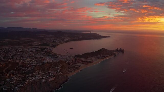 Peaceful aerial footage showing the Cabo San Lucas bay and coastline illuminated by warm sunrise light. Lands End, The Arch and Los Cabos, Baja California Sur, M&eacute;xico.
