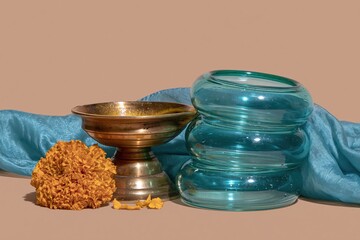 Fototapeta premium Polished brass diya and green glass bangles for Hariyali Teej festival, featuring a silk saree and orange marigold for cultural greeting card layouts