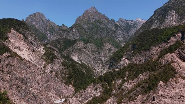 Steep rocky canyon facing the iconic Friulian Dolomites mountain peaks. Dramatic wilderness, Italy