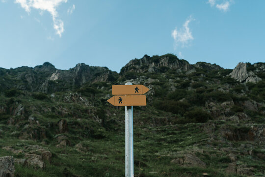Blank directional hiking trail signpost against a mountainous landscape.