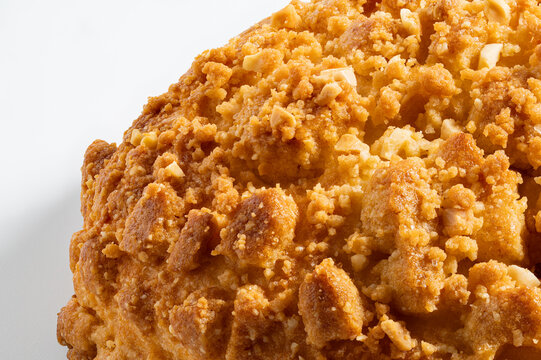 High-Resolution close-up of crunchy peanut crumble topping ultra sharp macro and extreme detail of golden streusel bakery bun texture