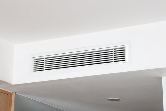 Air Condition (AC) at white ceiling vent with  sleek horizontal slats. Minimalist interior design. Clean lines and modern style. Ideal for home or office settings. Quiet, functional, unobtrusive detai