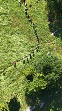 Drone Tracking Shot of a Crowd of Hikers on a Steep Mountain Trail