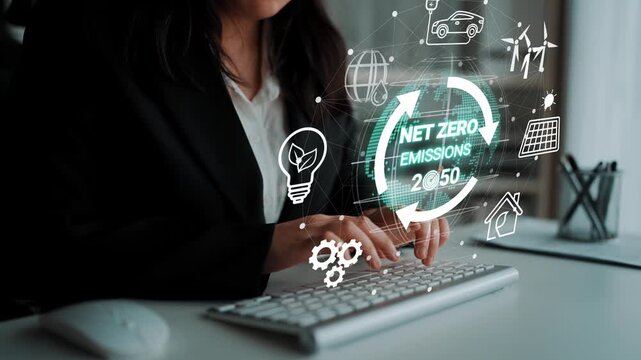 Business professional working on a keyboard with digital icons representing sustainability, net zero emissions, and eco-friendly technology goals for 2050. Entropy.