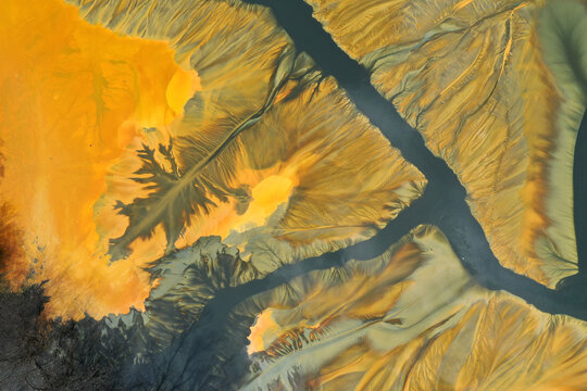 Surreal colorful natural pattern of mining waste waters in decanting lake aerial view