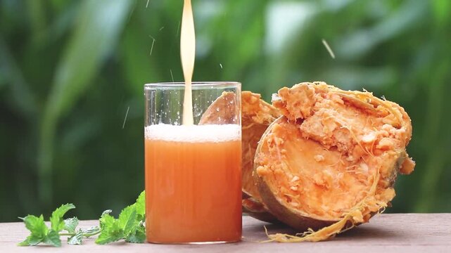 stone apple, or wood apple healthy juice with a natural green background. 