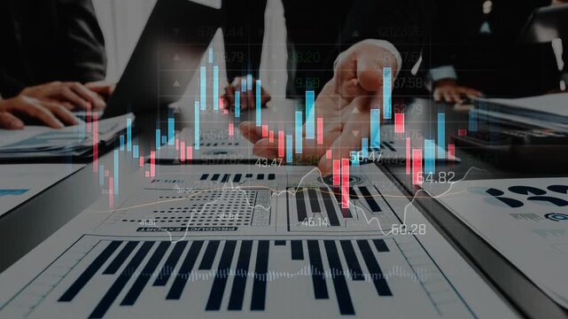 A group of business professionals analyzes financial data and charts on a table in a modern office, showcasing teamwork and strategic planning. Raster